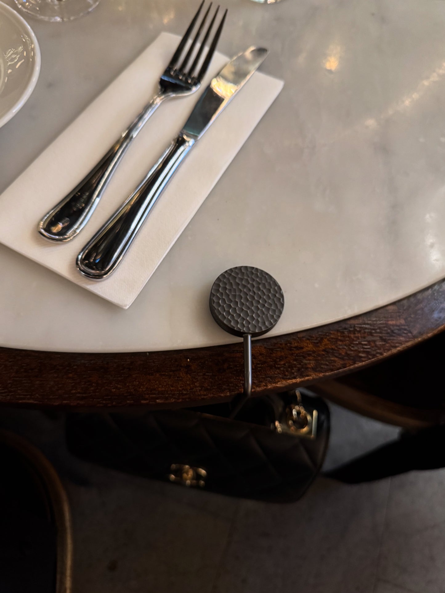 Elegant handbag hook designed to keep your designer bag off the floor at restaurants.