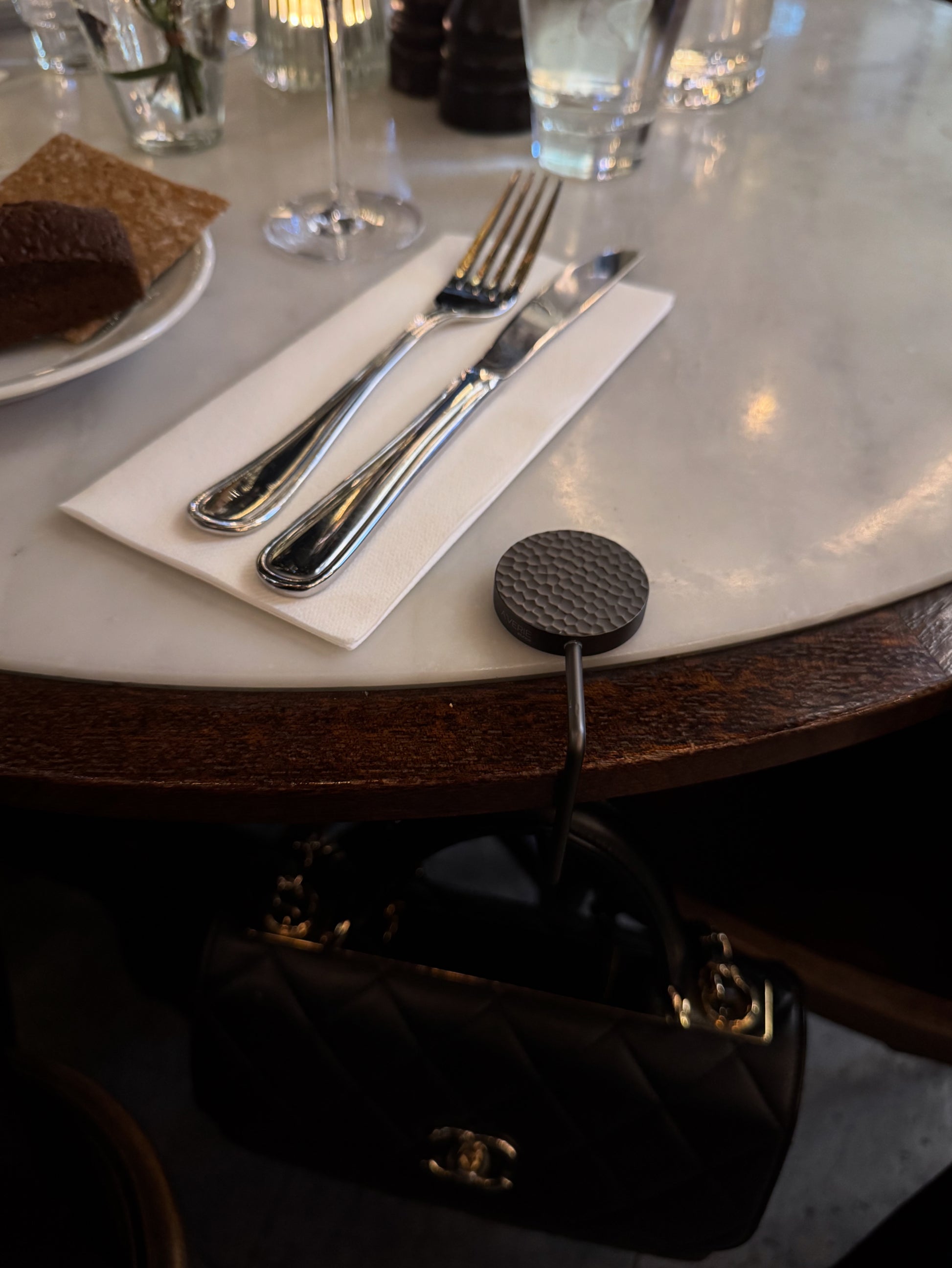Elegant handbag hook designed to keep your bag off the floor at restaurants.