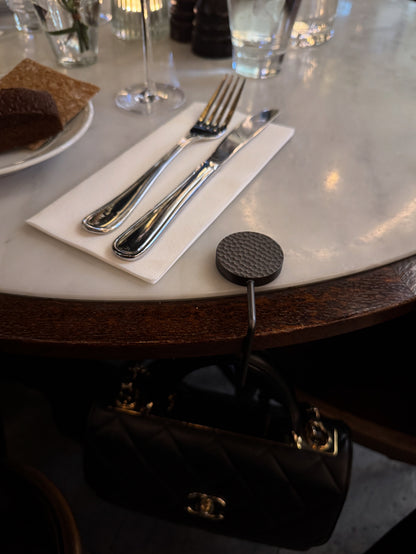 Elegant handbag hook designed to keep your bag off the floor at restaurants.